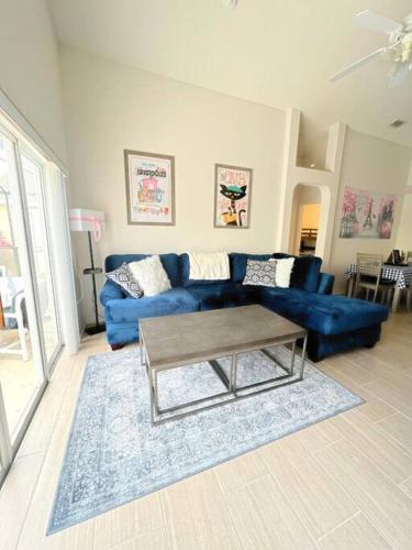奥兰多Clermont Vacation Homes by DWS Vacation的客厅配有蓝色的沙发和茶几