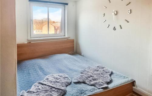 斯塔德Amazing Apartment In Ystad With 1 Bedrooms的卧室配有一张床,墙上挂着一个钟