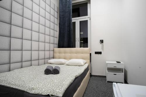 罗兹Dream Aparts - Narutowicza 24 FILHARMONIA的一间卧室,床上有两双鞋