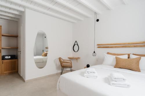 凯勒里瓦迪佩内洛普村酒店的白色卧室配有一张白色的大床和一把椅子