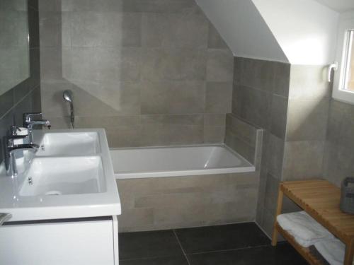 利克维Villa de charme Alsace - Riquewihr的浴室配有盥洗盆和浴缸。