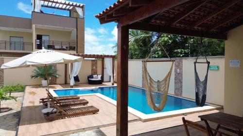 圣阿马鲁RECANTO DAS ÁGUAS VILLE的一座带游泳池和遮阳伞的房子