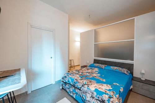 CaltabellottaLA MANDORLA Luxury Rooms的一间卧室配有一张带蓝色棉被的床
