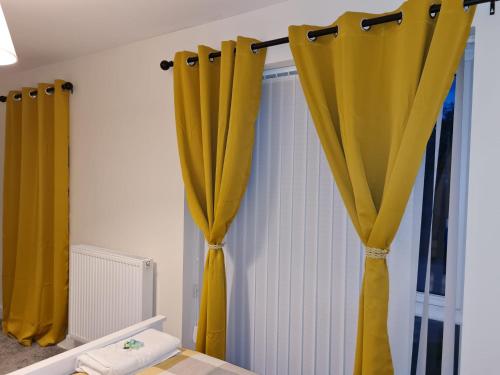 德比Mills Home Stays的墙上有黄色窗帘的房间