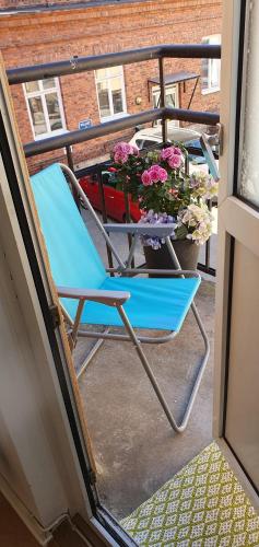 舍夫德Centrum lägenhet的阳台的蓝色椅子,带桌子和鲜花