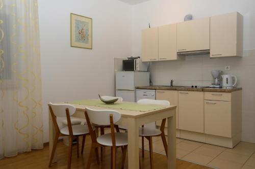 赫瓦尔Apartments Stipe Plazibat的厨房配有桌子、椅子和柜台