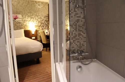 巴黎蒙帕纳斯提姆敖德萨酒店的带浴缸的浴室和1间带1张床的卧室