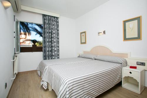 帕尔马诺瓦阿瓜索尔公寓酒店的白色的卧室设有床和窗户