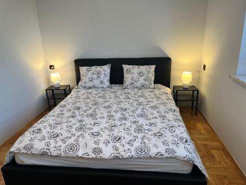 瓦多维采Apartament Wojska Polskiego 45的一张带黑白棉被的床和两盏灯