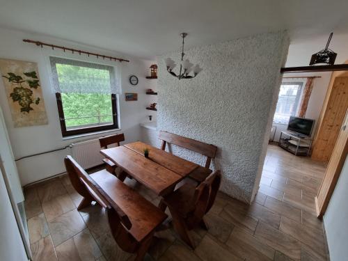 乌帕河畔斯沃博达Ubytování - Černá hora II的一间带木桌和椅子的用餐室