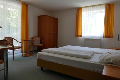 梅森希尔本奈申酒店的卧室配有床、桌子和窗户。