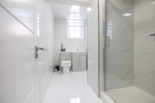 莱斯特The Pocklington - The Guild Suite的白色的浴室设有卫生间和淋浴。