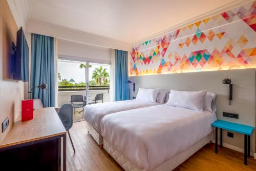 阿加迪尔Allegro Agadir的酒店客房设有一张大床,拥有色彩缤纷的天花板