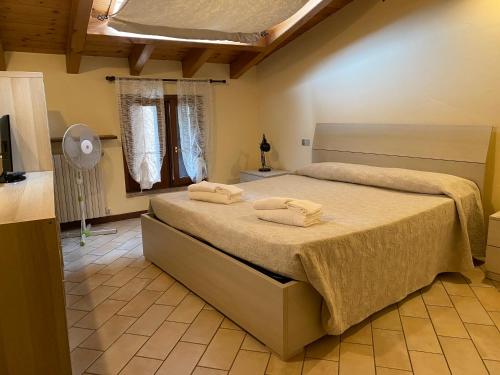 托斯科拉诺-马德尔诺亚德里亚度假酒店的一间卧室配有一张床,上面有两条毛巾