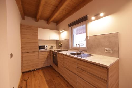 巴切诺Casa Vacanze Le Falesie的厨房配有木制橱柜、水槽和窗户。