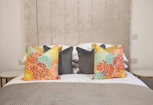 莱斯特The Pocklington - The New Walk Suite的床上有色彩缤纷的枕头