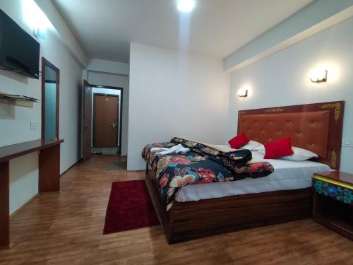 拉瓦格拉Sikkimese Inn的一间卧室配有一张床和一台电视