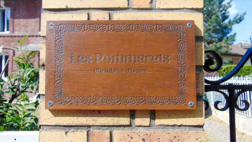 Le Petit-CouronneLes Pommerets的砖砌建筑一侧的木标志