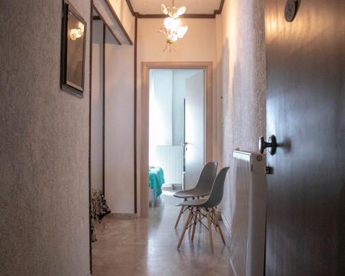 帕拉利亚狄奥尼索Maria Apartments的走廊上设有椅子和桌子
