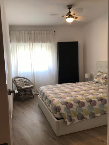 波尔蒂芒New Casa Praia da Rocha的卧室配有床、椅子和窗户。
