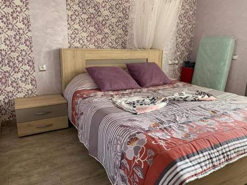 卡萨布兰卡Lhaja home的一间卧室配有一张带紫色枕头的大床