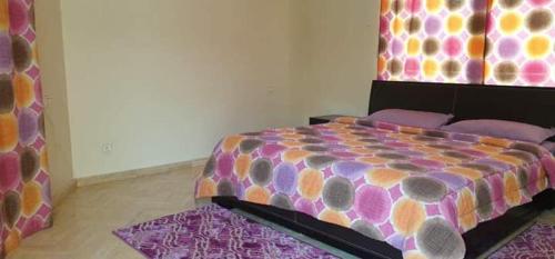 卡萨布兰卡Lhaja home的一间卧室配有一张带五颜六色棉被的床