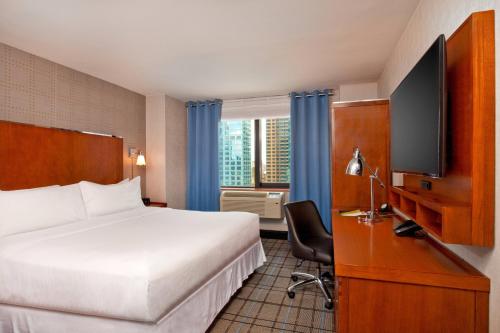 纽约市区时代广场福朋喜来登酒店的配有一张床和一台平面电视的酒店客房
