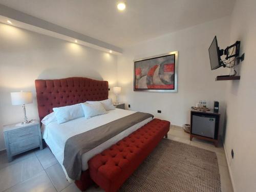 莫雷利亚Casa Allende Morelia的一间卧室配有一张红色的大床和一张红色的沙发