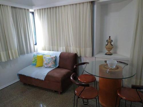 福塔莱萨Lindo Flat Beira Mar 401的带沙发和玻璃桌的客厅