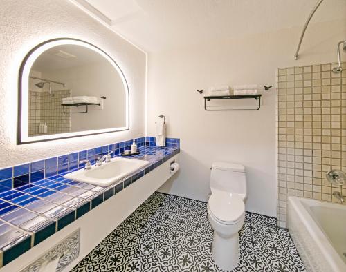 半月湾半月湾旅舍的一间带水槽、卫生间和镜子的浴室