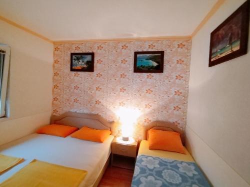 尤塔哈Apartmani LJUBICA的小房间设有两张床,墙上有灯