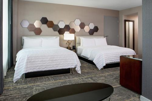剑桥剑桥波士顿艾美酒店的酒店客房,配有两张带白色床单的床