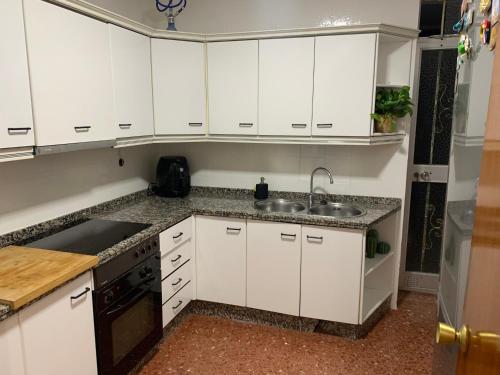 科尔多瓦Room Valdeolleros的厨房配有白色橱柜和水槽
