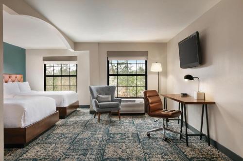 罗利Four Points by Sheraton Raleigh Arena的酒店客房,配有一张床、一张桌子和椅子