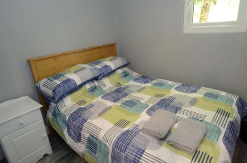 韦斯特波特Tawny Lodge的卧室里一张带两条毛巾的床