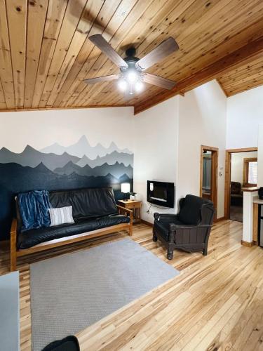 伍德兰帕克Cozy Cabin suite bed and breakfast的带沙发和吊扇的客厅