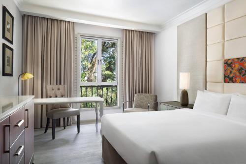 阿鲁沙阿鲁沙福朋喜来登酒店的配有一张床、一张书桌和一扇窗户的酒店客房