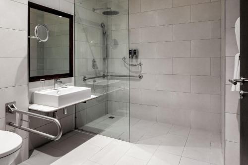 阿鲁沙阿鲁沙福朋喜来登酒店的一间带玻璃淋浴和水槽的浴室