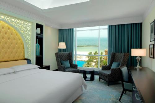 沙迦沙迦海滩喜来登Spa度假酒店的酒店客房,配有一张床、一张桌子和椅子