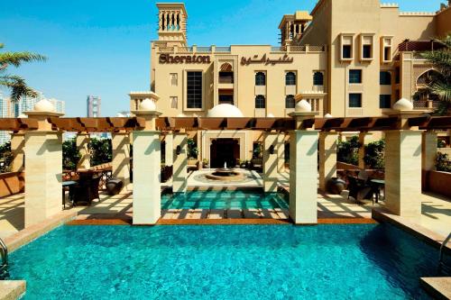 沙迦沙迦海滩喜来登Spa度假酒店的大楼前带游泳池的房子