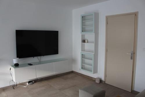 勒图凯-巴黎普拉日Appt 4 pers avec parking privé gratuit Le Touquet的客厅配有白色墙壁上的平面电视。
