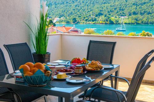 格雷巴蒂卡Sea View Apartments的一张桌子,上面有食物,享有水景