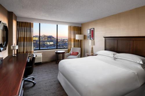费城费城大学城喜来登酒店的酒店客房设有一张白色大床和一张书桌