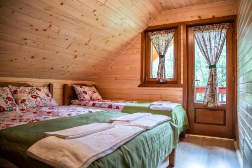 VărşagCentral Chalet的小木屋内一间卧室,配有两张床