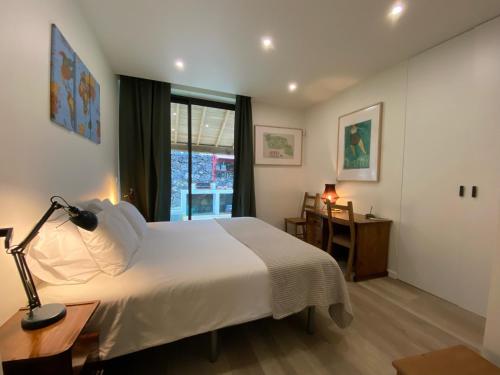 拉戈阿CaLoura 76的一间卧室配有一张床、一张书桌和一个窗户。