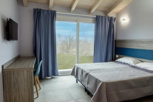 卡伊罗蒙泰诺泰Ca' Brichella的一间卧室设有一张床和一个大窗户