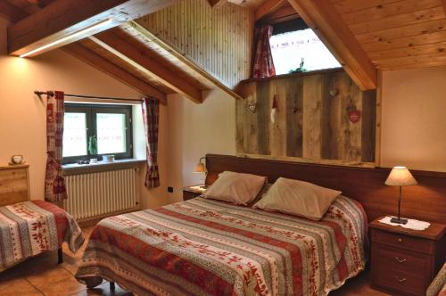 BionazAppartamenti Luseney的一间卧室设有一张床和两个窗户。