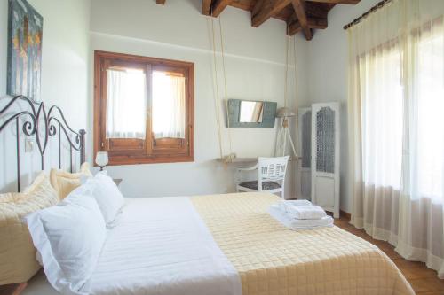 SívrosTraditional family villa southern lefkada的一间卧室配有一张带白色床单的床和一扇窗户。