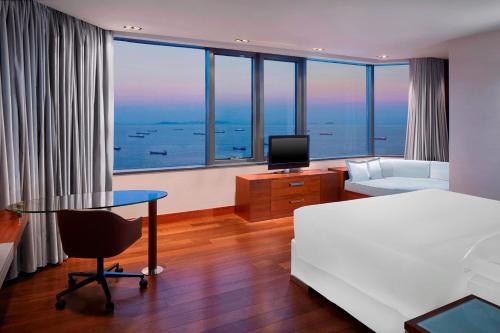 伊斯坦布尔伊斯坦布尔阿塔科尤喜来登酒店的酒店客房配有一张床、一张书桌和一台电视。