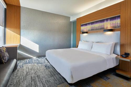 阿什本杜勒斯机场北雅乐轩酒店的一张大白色的床,位于一个配有沙发的房间